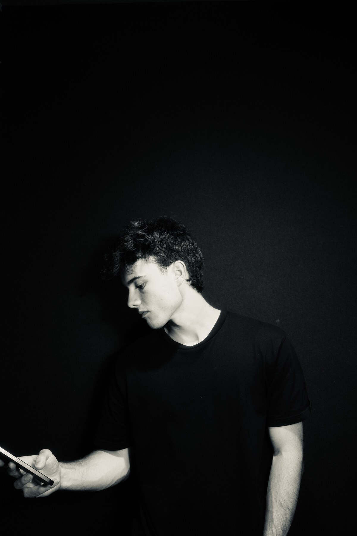 Portrait of Matyas Mayo, looking down at phone