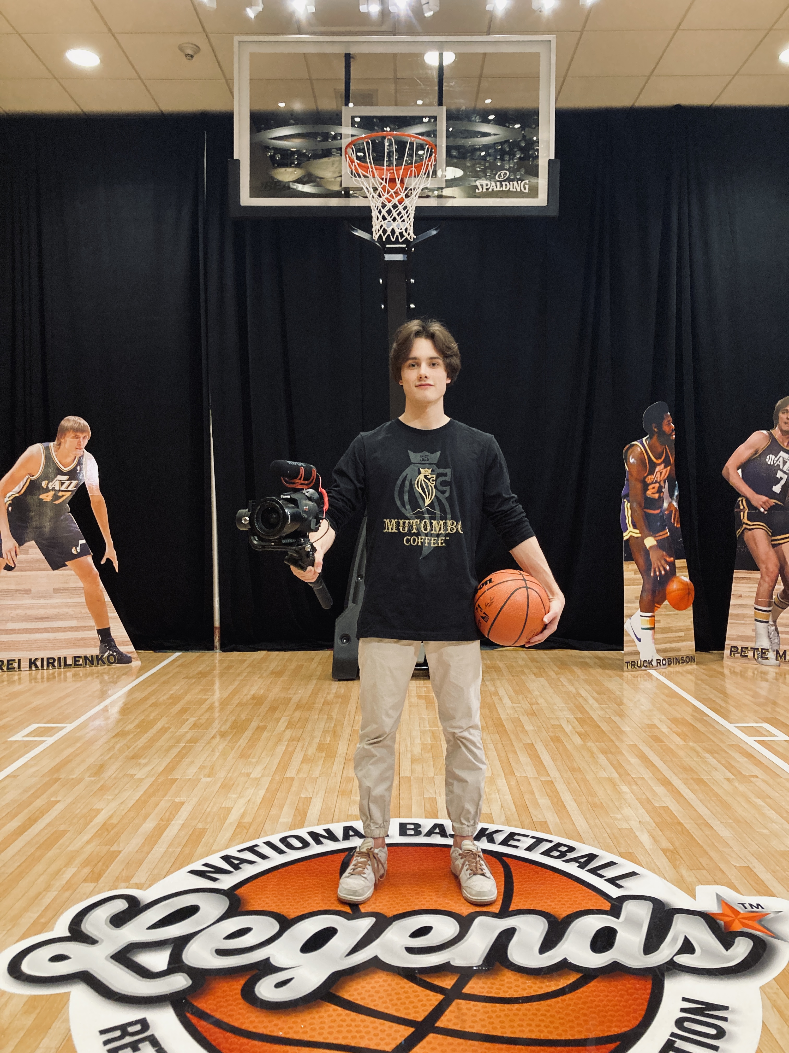 Matyas Mayo holding a camera and basketball at the NBA Legends court