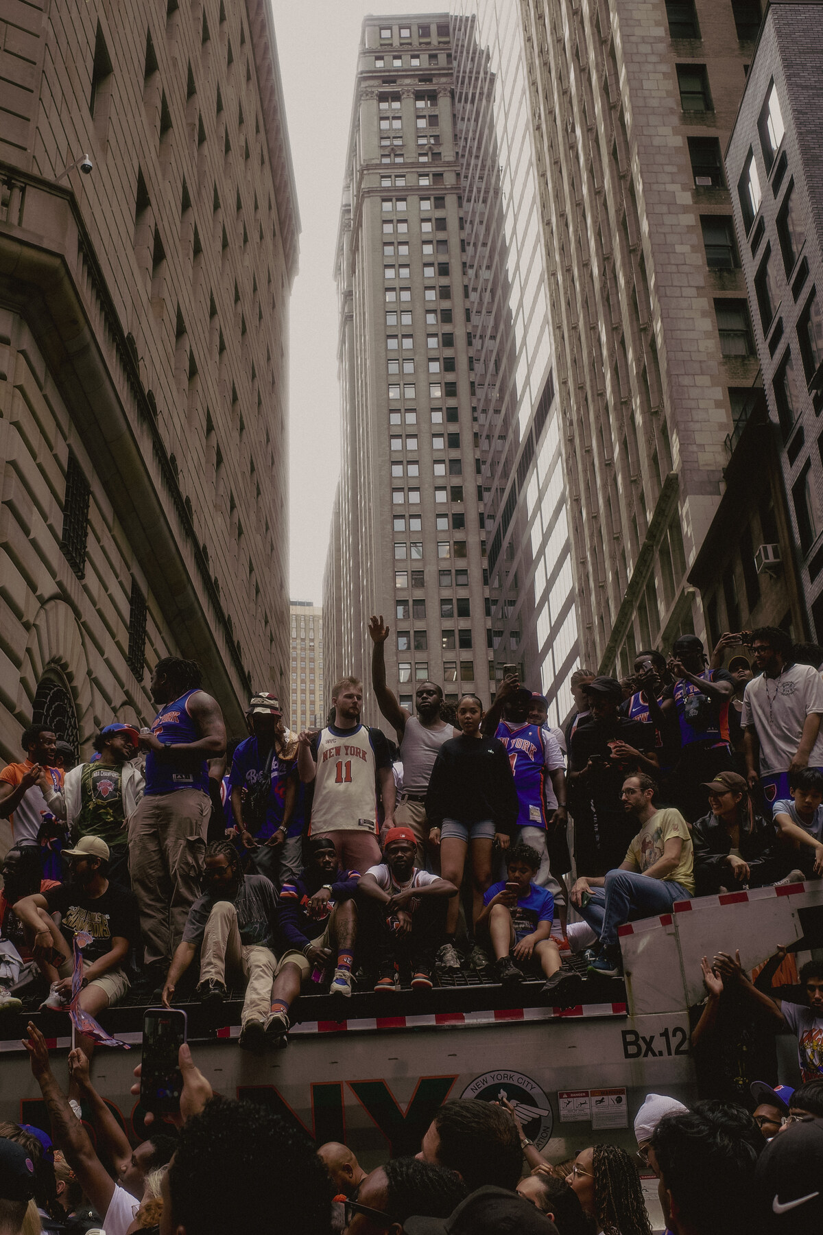 Knicks parade crowd on trucks, wide shot between skyscrapers